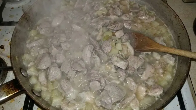 Sartén sobrecargada con carne soltando agua y sin dorar.